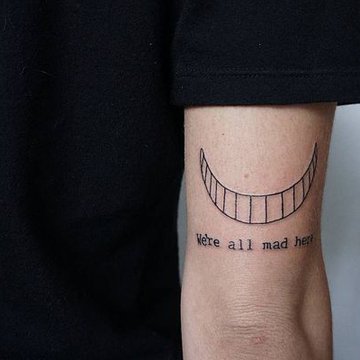 The-Cheshire-Сat-Mouth-Tattoo-With-Words-on-the-Arm.jpg