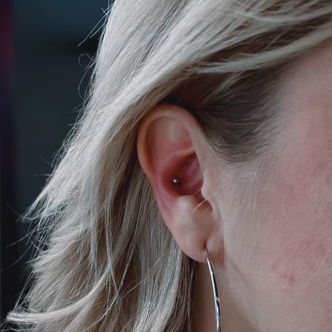 Конч - пирсинг внутренней части уха с аккуратным акцентом. Точное выполнение, стерильные условия и стабильное заживление.
